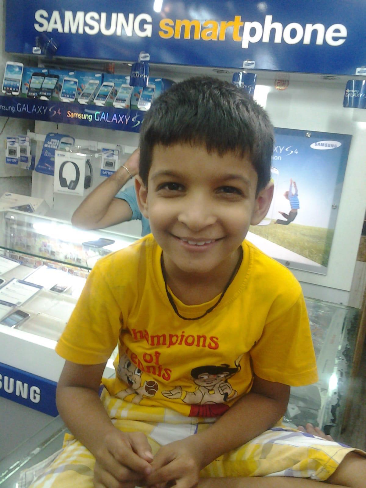 A childhood photo smiling in a yellow shirt